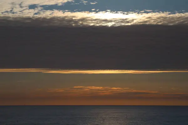 Kıyı açıklarında bulutlu gün batımı Kuzey denizi