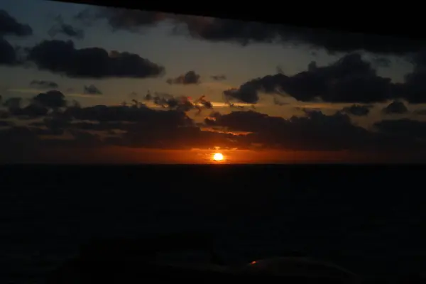 Kıyı açıklarında bulutlu gün batımı Kuzey denizi