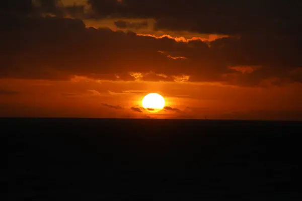Kıyı açıklarında bulutlu gün batımı Kuzey denizi
