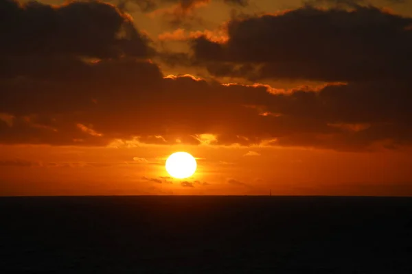 Kıyı açıklarında bulutlu gün batımı Kuzey denizi