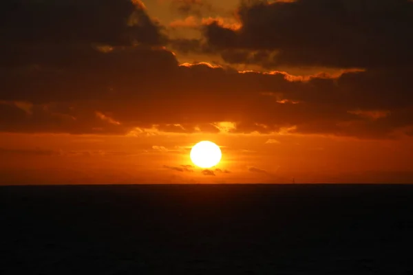 Kıyı açıklarında bulutlu gün batımı Kuzey denizi