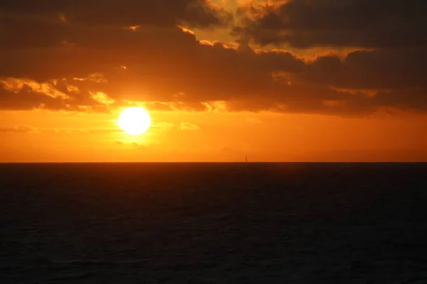 Kıyı açıklarında bulutlu gün batımı Kuzey denizi