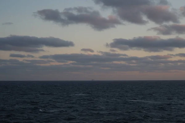 Kıyı açıklarında bulutlu gün batımı Kuzey denizi