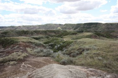A panaramic view of a desert badlands with canyons on a cloudy day.