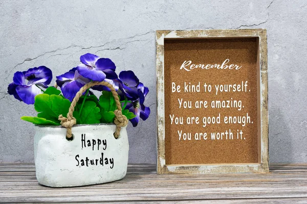 Motivational quote wooden frame and happy saturday words on the potted plant.