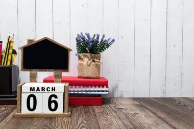 March 06 calendar date text on white wooden block with stationeries on wooden desk. Calendar date concept.