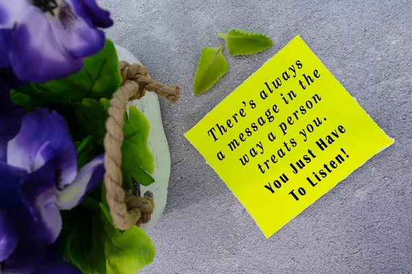 Motivational quote on yellow note with flowers - Theres always a message in the way a person treats you. You just have to listen.