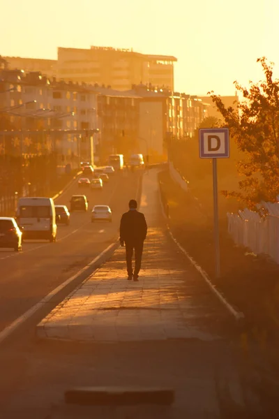 At the end of the day, everyone returns home. So is sunset. A man walking alone with his back turned..