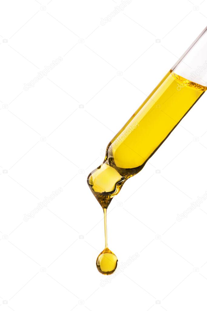 Dropper with cosmetic oil drop isolated on white background. Abstract drop of skin care oil.