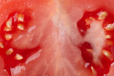 Tohumlu yarım doğranmış domates diliminin Macro fotoğrafı. Domates dilimi dokusu. 