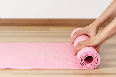 Kadın egzersiz paspası salonda sallanıyor. Yoga ya da evde spor yapmak..