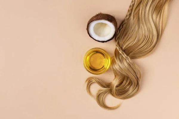 Coconut oil for restore and recovery damaged hair. Hair curl, coconut and oil top view with copy space.