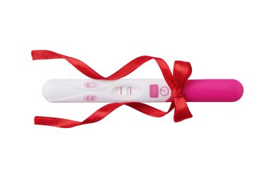 Pink positive pregnancy test with red ribbon isolated on white background. Positive result of pregnancy test.