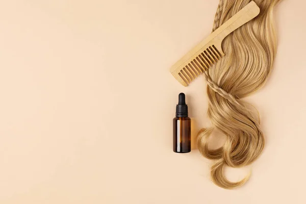 Bottle of oil for restore and recovery damaged hair. Hair curl and hair oil top view.