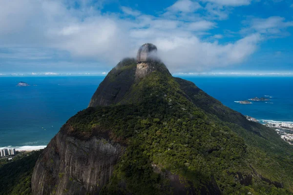 Okyanusa ve şehre bakan bulutların içindeki dağ
