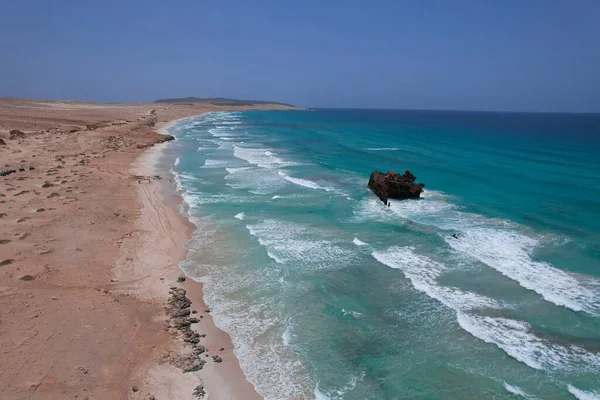 Okyanusta batık bir gemi kumsalın yanında, drone manzaralı.