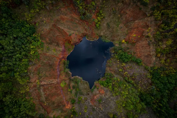 Karanlık suları ve sonbahar ormanlarıyla gölün güzel manzarası.