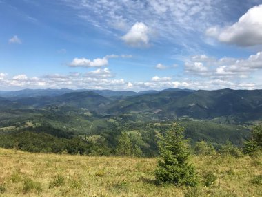 Dağları ve mavi gökyüzü olan güzel bir manzara.