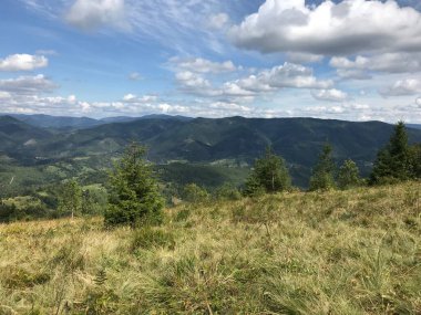 Dağları ve mavi gökyüzü olan güzel bir manzara.