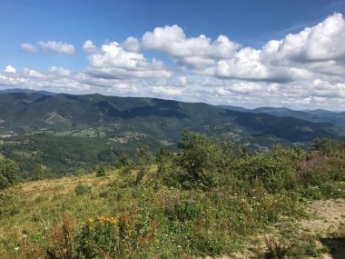 Dağları ve mavi gökyüzü olan güzel bir manzara.