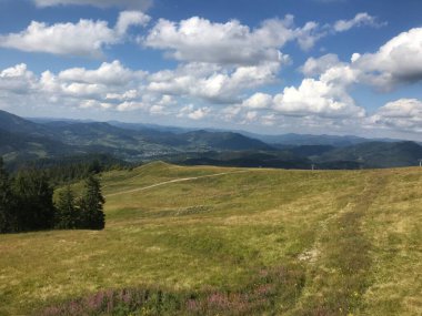 Dağları ve mavi gökyüzü olan güzel bir manzara.