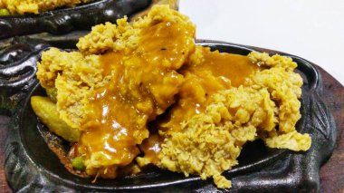 Izgara tavuk bifteği, barbekü sosu ve sebze soteli fırında servis edilir.