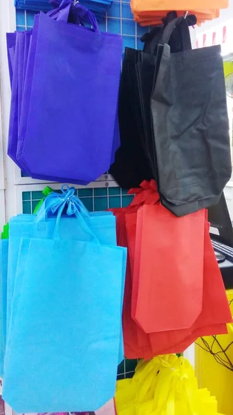 colorful tote bags hanging on the factory outlet stand