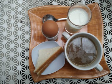 cup of tea with egg and a jug of milk