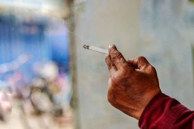 Sigara içerken arka planda bir el dumanı vardı.