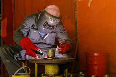 Koruyucu üniformalı kaynakçı kılıçlı.