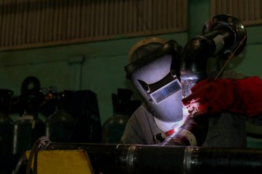 worker in a protective helmet with a metal pipe