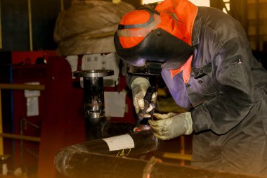 Koruyucu eldivenleri ve kaynak metali olan bir işçi.