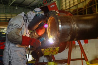 Kaynakçı metali kıvılcımlarla kaynıyor