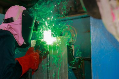 Fabrikada maskeyi kaynak yapan işçi.