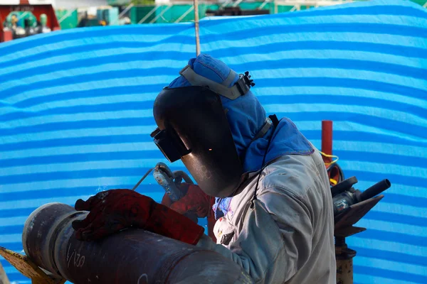 man in a protective suit with a mask and a blue jacket