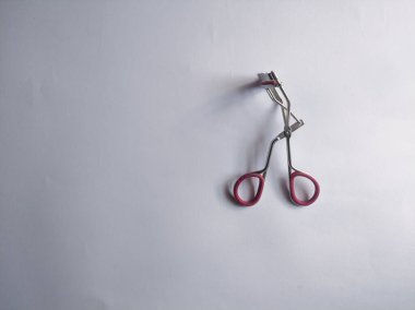 Eyelash curlers isolated over gray background.