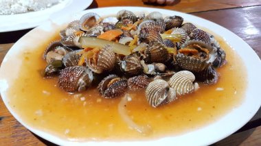 Tatlı ve ekşi deniz tarakları, işlenmiş taze kabuklu deniz ürünleri, acı biber sosu, domates, zencefil, bombay, sarımsak ve istiridye sosuyla pişirilmiş bir yemektir.