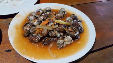 Tatlı ve ekşi deniz tarakları, işlenmiş taze kabuklu deniz ürünleri, acı biber sosu, domates, zencefil, bombay, sarımsak ve istiridye sosuyla pişirilmiş bir yemektir.