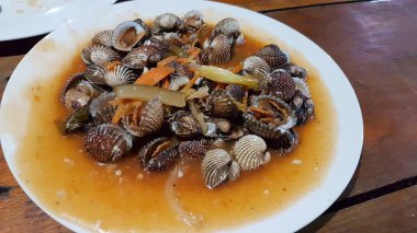 Tatlı ve ekşi deniz tarakları, işlenmiş taze kabuklu deniz ürünleri, acı biber sosu, domates, zencefil, bombay, sarımsak ve istiridye sosuyla pişirilmiş bir yemektir.