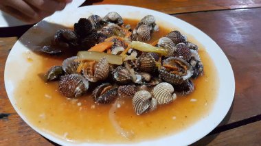 Tatlı ve ekşi deniz tarakları, işlenmiş taze kabuklu deniz ürünleri, acı biber sosu, domates, zencefil, bombay, sarımsak ve istiridye sosuyla pişirilmiş bir yemektir.