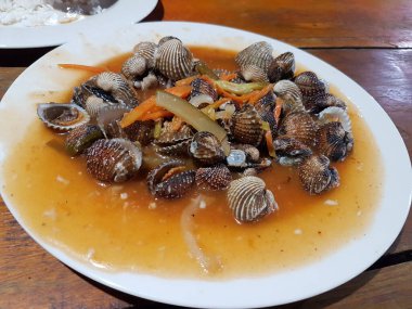 Tatlı ve ekşi deniz tarakları, işlenmiş taze kabuklu deniz ürünleri, acı biber sosu, domates, zencefil, bombay, sarımsak ve istiridye sosuyla pişirilmiş bir yemektir.