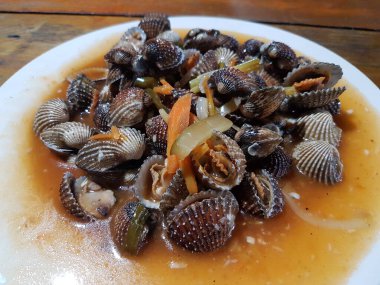 Tatlı ve ekşi deniz tarakları, işlenmiş taze kabuklu deniz ürünleri, acı biber sosu, domates, zencefil, bombay, sarımsak ve istiridye sosuyla pişirilmiş bir yemektir.