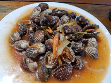 Tatlı ve ekşi deniz tarakları, işlenmiş taze kabuklu deniz ürünleri, acı biber sosu, domates, zencefil, bombay, sarımsak ve istiridye sosuyla pişirilmiş bir yemektir.