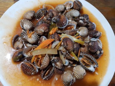 Tatlı ve ekşi deniz tarakları, işlenmiş taze kabuklu deniz ürünleri, acı biber sosu, domates, zencefil, bombay, sarımsak ve istiridye sosuyla pişirilmiş bir yemektir.