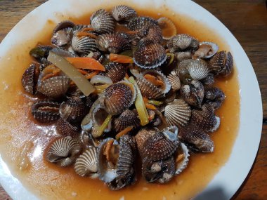 Tatlı ve ekşi deniz tarakları, işlenmiş taze kabuklu deniz ürünleri, acı biber sosu, domates, zencefil, bombay, sarımsak ve istiridye sosuyla pişirilmiş bir yemektir.