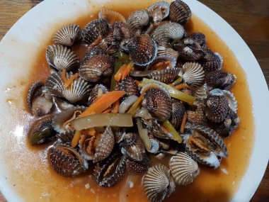 Tatlı ve ekşi deniz tarakları, işlenmiş taze kabuklu deniz ürünleri, acı biber sosu, domates, zencefil, bombay, sarımsak ve istiridye sosuyla pişirilmiş bir yemektir.