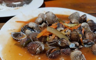 Tatlı ve ekşi deniz tarakları, işlenmiş taze kabuklu deniz ürünleri, acı biber sosu, domates, zencefil, bombay, sarımsak ve istiridye sosuyla pişirilmiş bir yemektir.