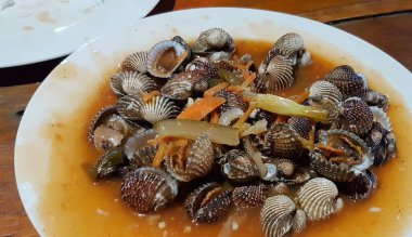 Tatlı ve ekşi deniz tarakları, işlenmiş taze kabuklu deniz ürünleri, acı biber sosu, domates, zencefil, bombay, sarımsak ve istiridye sosuyla pişirilmiş bir yemektir.