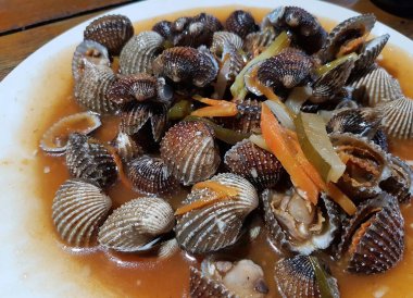 Tatlı ve ekşi deniz tarakları, işlenmiş taze kabuklu deniz ürünleri, acı biber sosu, domates, zencefil, bombay, sarımsak ve istiridye sosuyla pişirilmiş bir yemektir.