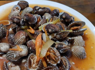 Tatlı ve ekşi deniz tarakları, işlenmiş taze kabuklu deniz ürünleri, acı biber sosu, domates, zencefil, bombay, sarımsak ve istiridye sosuyla pişirilmiş bir yemektir.